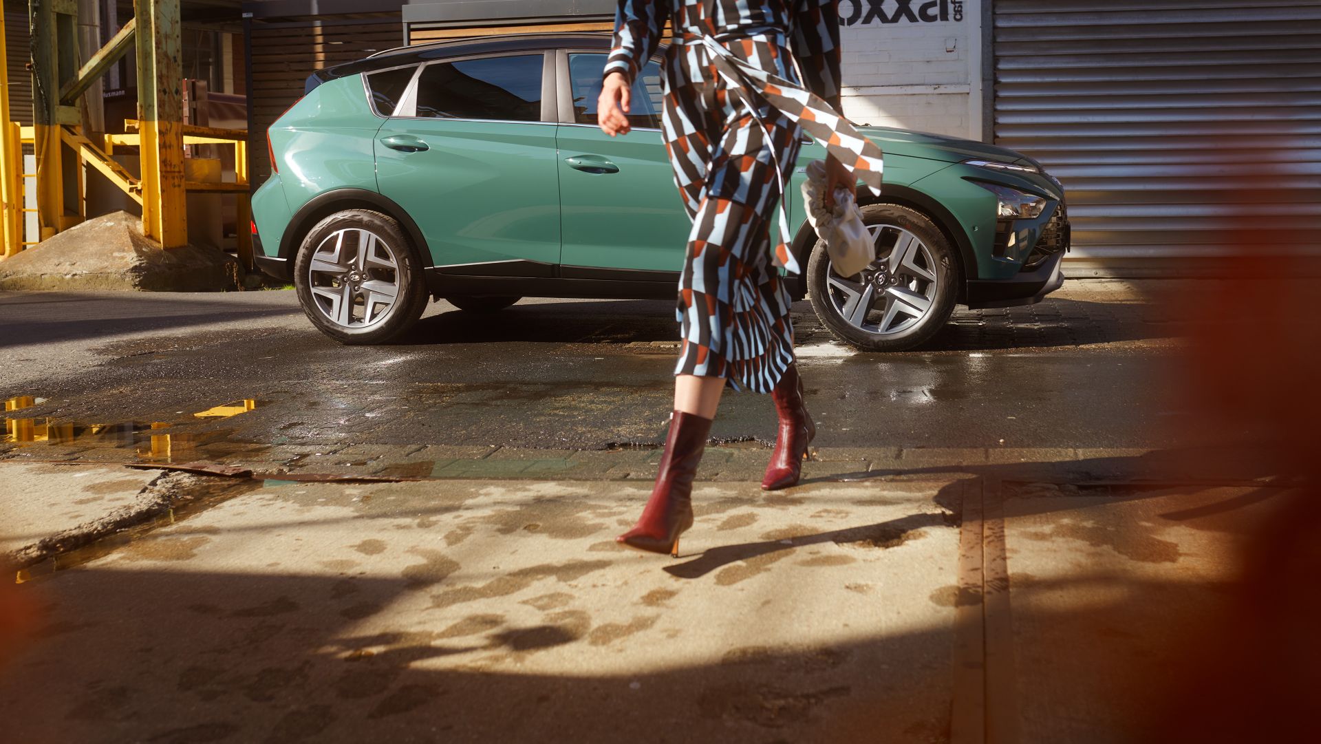 Women crossing the street with the all-new Hyundai BAYON compact crossover SUV standing in the back.