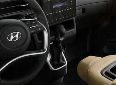 A detailed view of the all-new STARIA's driving wheel and stylish gearshift in the centre console.
